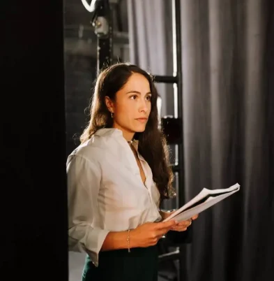 Paula Sanz sostiene un guion entre bambalinas y prepara una sesión de coaching escénico en un teatro (Terapia Escénica).