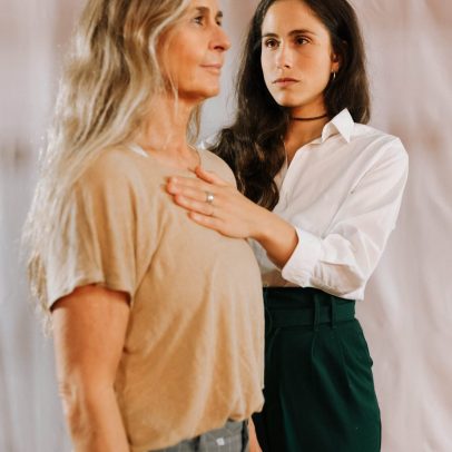 Una profesional acompaña a una actriz colocando la mano sobre su pecho para regular la respiración y recuperar calma.