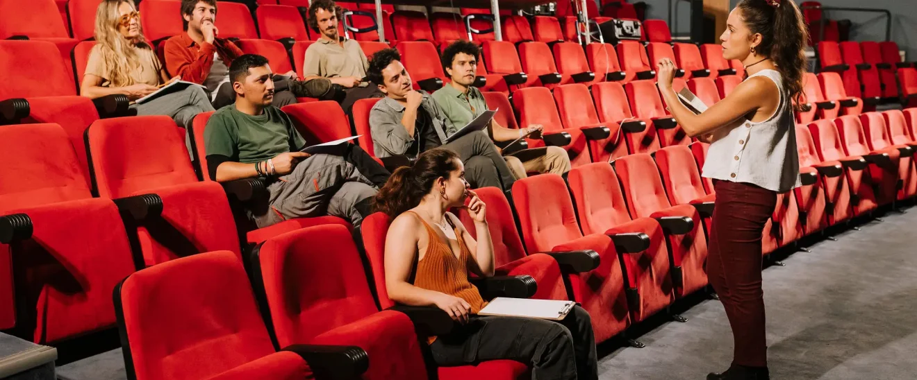 Paula Sanz guía una sesión de terapia escénica en grupo para actores en un teatro