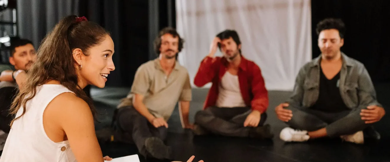 Terapia escénica en grupo con actores en un teatro, guiada por Paula Sanz