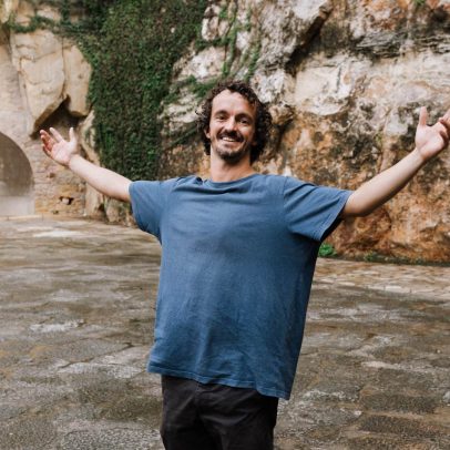 Actor sonríe con los brazos abiertos en un espacio exterior, símbolo de bienestar y crecimiento personal en terapia individual.