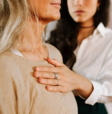 Primer plano de una mano sobre el pecho de una mujer durante un ejercicio corporal de regulación emocional en terapia integrativa (Terapia Escénica).